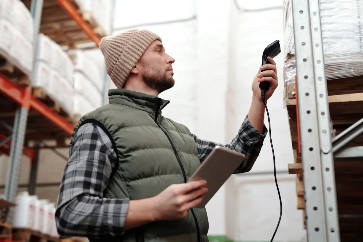 Fulfilment team member scanning stock with a handheld scanner and tablet